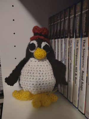 A knitted penguin with a red heat, taken with the Fairphone camera app.